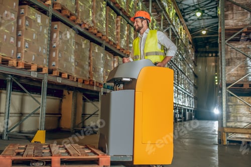 Preview: Megastore. Warehouse Worker In Yellow Vest Working In The Warehouse And Looking Busy
