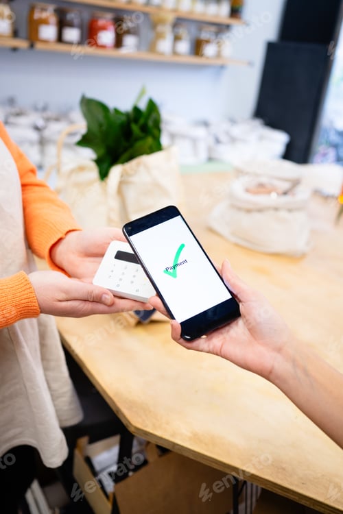 Preview: Customer paying with mobile phone in zero waste store