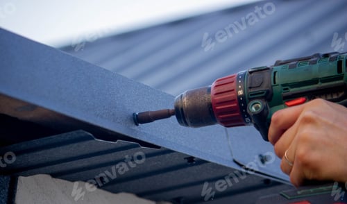 Preview: a man repairs the roof, tightens the self-tapping screw with a screwdriver