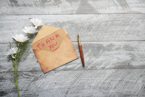 Preview: thank you message and envelope on wooden table