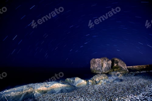 Preview: Sea sandy beach with boulders in moon light
