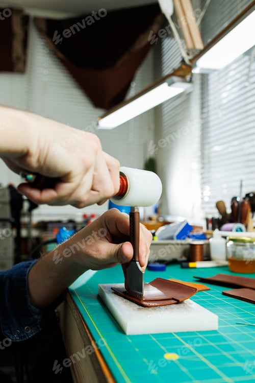 Preview: The hands of the master sew handmade leather products. Men's hands connect the parts