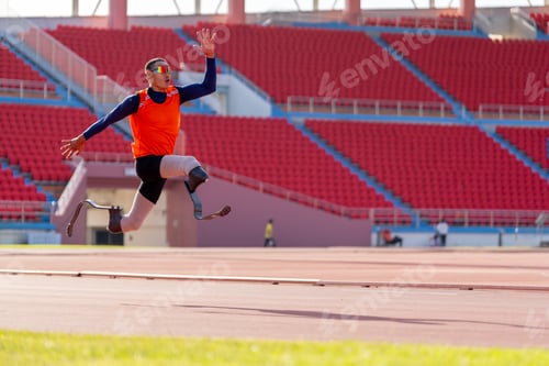 Preview: Asian para-athletes with prosthetic blades sprint on a running track at stadium.