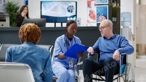 Preview: African american nurse consulting senior man in wheelchair