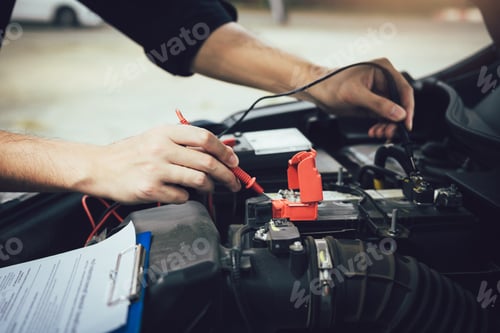 Preview: Car mechanic is using the car battery meter to measure various values and analyze it.