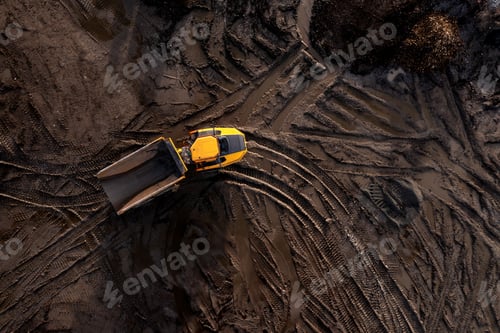 Preview: Aerial view above an earth mover truck on a muddy construction site
