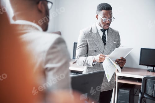 Preview: Modern businessman at work. Two confident business people in formalwear discussing something While