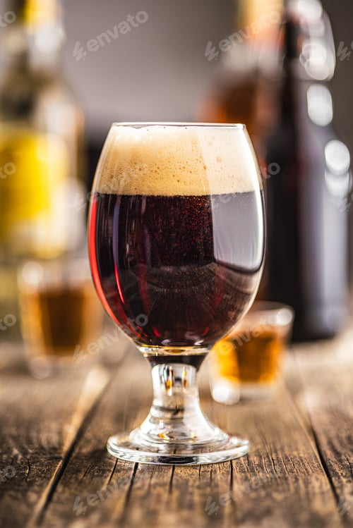 Vista previa: Dark beer in beer glass on wooden table.