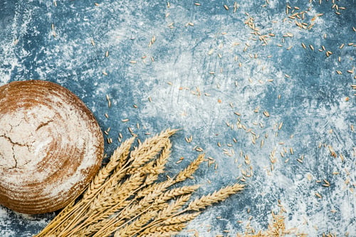 Preview: Loaf of Bread with Wheat on Blue Table