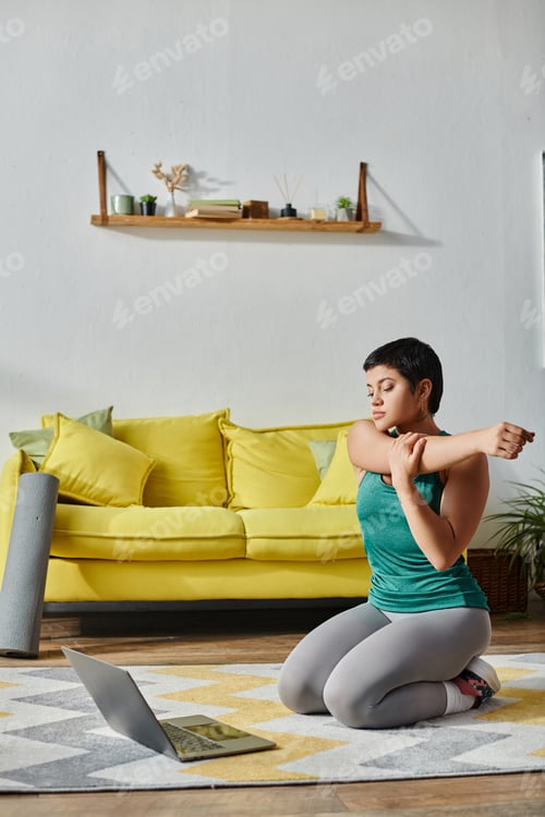 Preview: vertical shot of young woman in sportswear stretching during online fitness lesson, fitness