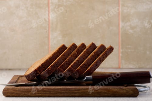 Preview: Triangular rye piece of bread on a wooden cutting board