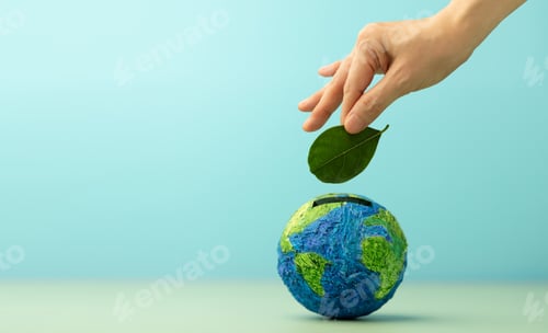 Preview: Hand drops a Green Leaf into Globe Piggy bank, Eco savings