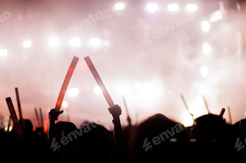 Preview: silhouettes of hand in concert.Light from the stage.