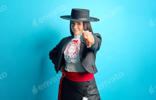 Preview: young woman proudly wearing a traditional chilean Huasa dress pointing finger at you