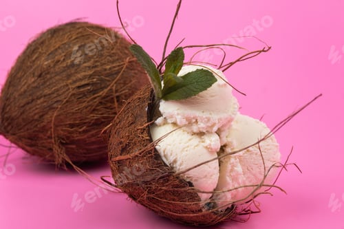 Preview: Vanilla ice cream balls in an empty coconut decorated with mint leaves on a pink background