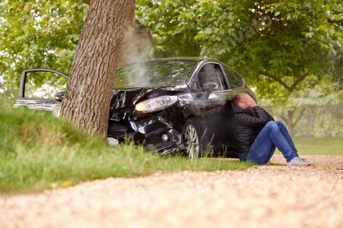 Preview: Teenage Driver With Head In Hands Sitting Next To Wrecked Car After Crashing Into Tree