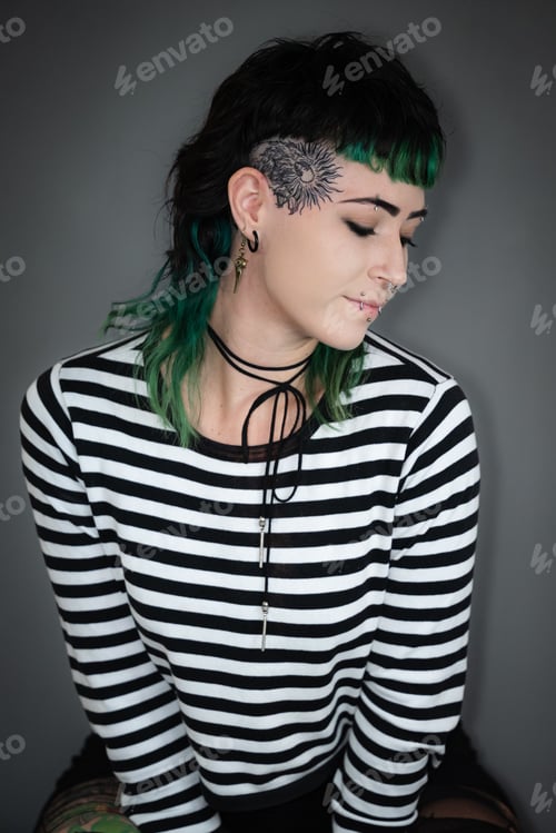 Preview: Young Caucasian woman with bright green hair sitting with closed eyes