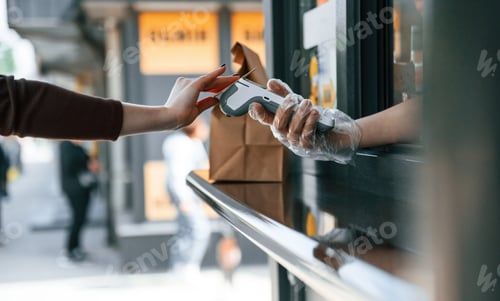 Preview: Customer is making payment by credit card. Man is serving delicious street food