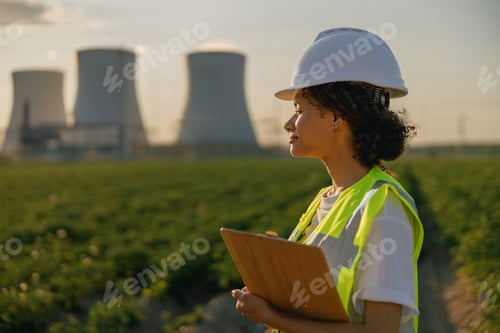 Preview: Female engineer constructor stands with clipboard on field on industrial enterprise background