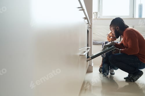 Preview: African American male watching the baking of biscuit with his daughter