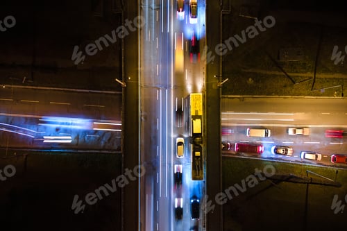 Preview: Aerial view of road intersection with fast moving heavy traffic at night.
