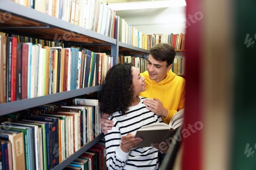 Preview: Students studying together near shelves with books in public library