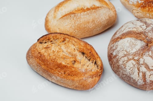 Preview: Freshly baked artisan bread loaves displayed on a white surface