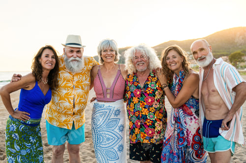 Preview: Happy group of senior friends bonding at the beach during summertime