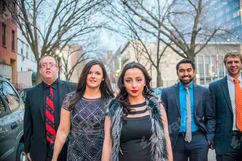 Preview: Portrait of four young adult friends on night out walking along street