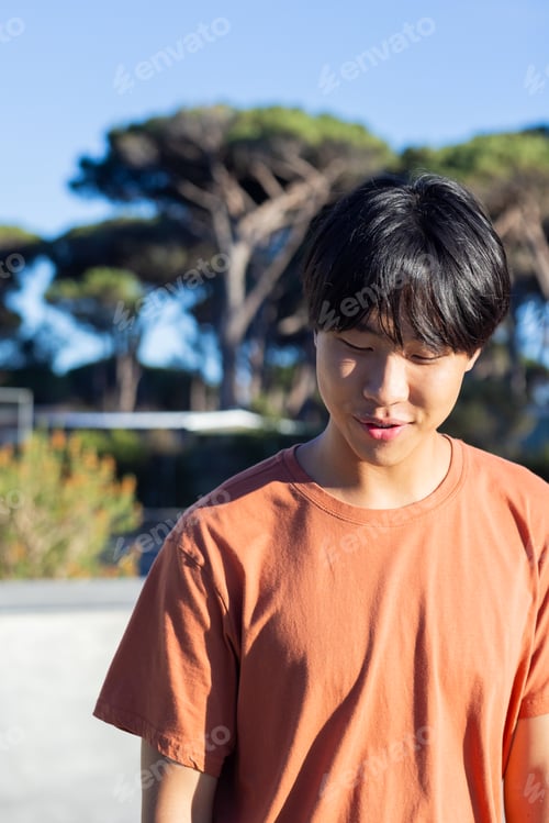 Preview: Smiling and enjoying sunny day, Asian male student standing outdoors