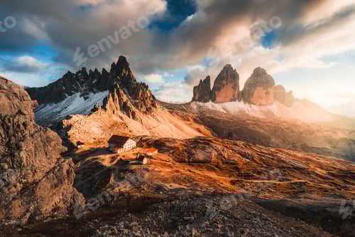 Preview: Alpine landscape of sunset over Tre Cime mountain peak and mountain hut in Dolomites