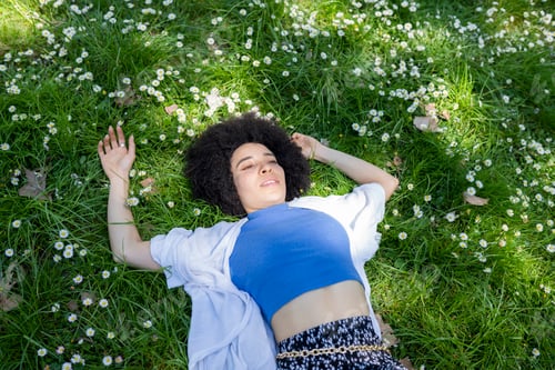 Preview: woman in the park lying on the grass, resting, relaxed, in spring
