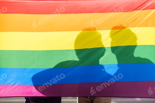 Preview: Rainbow lgtbi flag with an unrecognizable couple of boys in the background