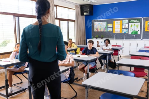 Preview: Standing in classroom, indian female teacher instructing while students at desks listening