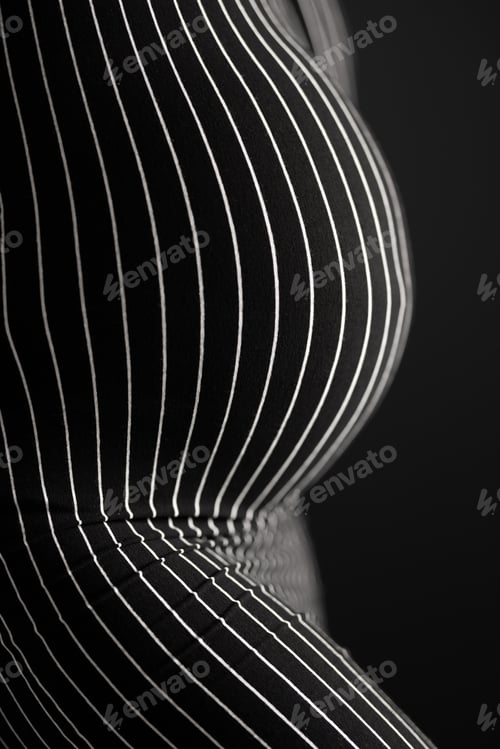 Vista previa: Curvy pregnant woman body in black and white striped pattern dress.