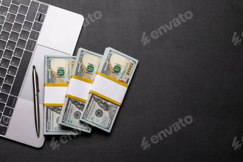 Preview: Office desk with cash money on laptop