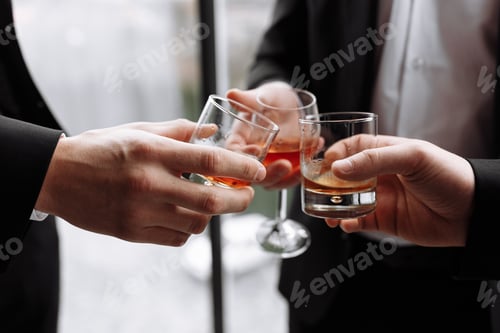 Preview: Business meeting. Men hold glasses of whiskey. Men's Party. Hand with a drink of alcohol