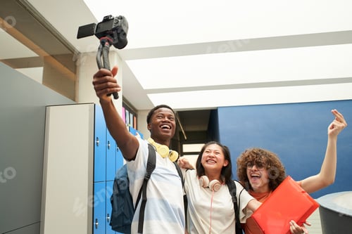 Preview: Group of smiling students blogging at school. Multiethnic group of young people