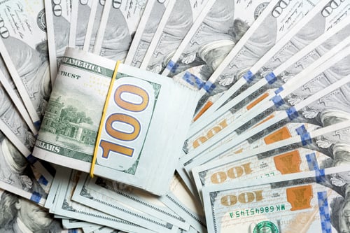 Preview: Top view of 100 rolled dollar bills on background made with one hundred dollar banknotes.