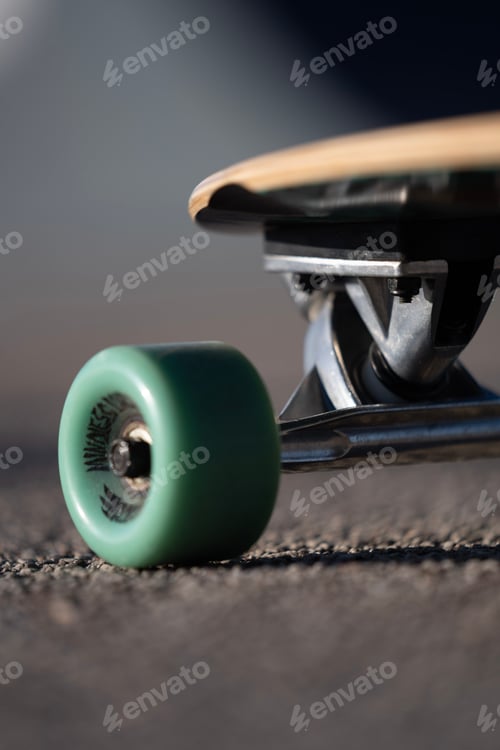 Preview: Vertical closeup of a skateboard on an asphalt road