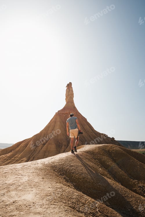 Preview: A traveler approaches the iconic Castildetierra formation in Bardenas Reales,