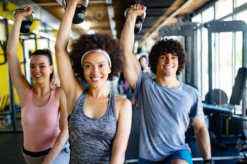 Preview: Group of young people doing exercises in gym
