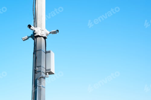 Preview: Outdoor CCTV camera system. Photo video city cameras mounted on pole against blue sky with copy