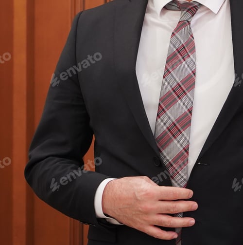 Preview: Closeup of an adult Caucasian businessman buttoning up his suit before the meeting
