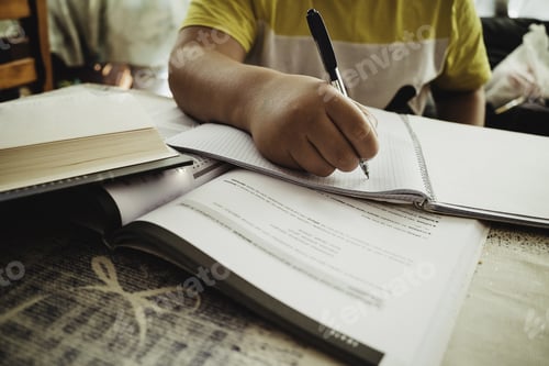 Preview: Closeup focus shot of a kid doing homework - concept of studying