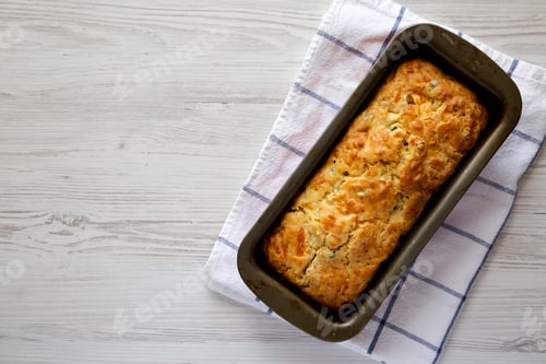 Preview: Homemade Cheesy Bread Loaf on a white wooden background, top view.