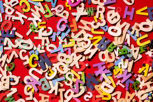 Preview: Top view of many wooden colorful alphabet with numbers on red table top