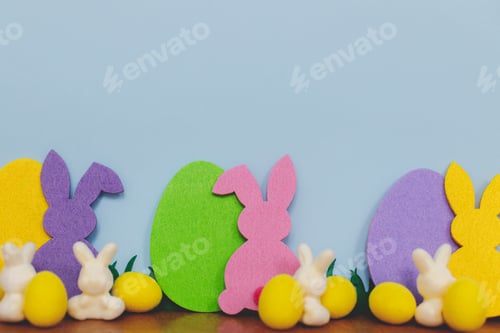 Preview: Happy Easter! Colorful Easter bunnies and eggs on blue background with space for text