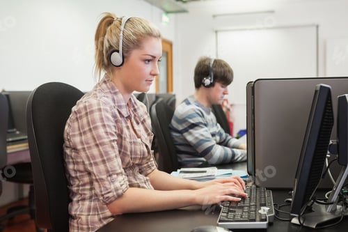 Preview: Student Working In Computer Class Wearing Headphones In College