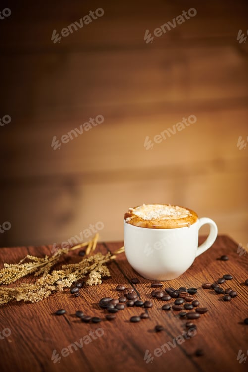 Preview: Vertical shot of cream coffee on a wooden table with scattered beans